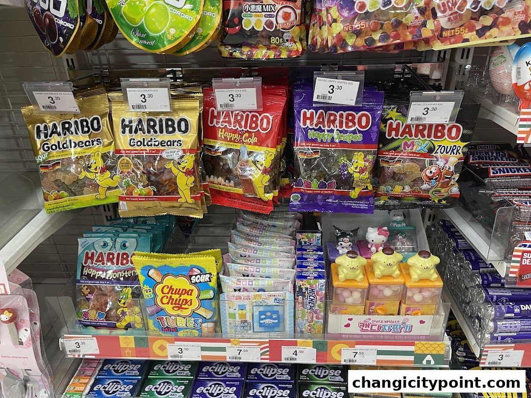 A display of various candies and snacks, including Haribo gummies and Chupa Chups, at a 7-Eleven store.