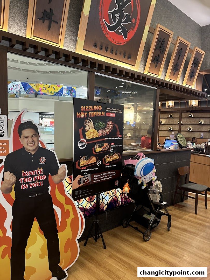 Aburi-EN restaurant entrance with a life-size cutout and a menu board.