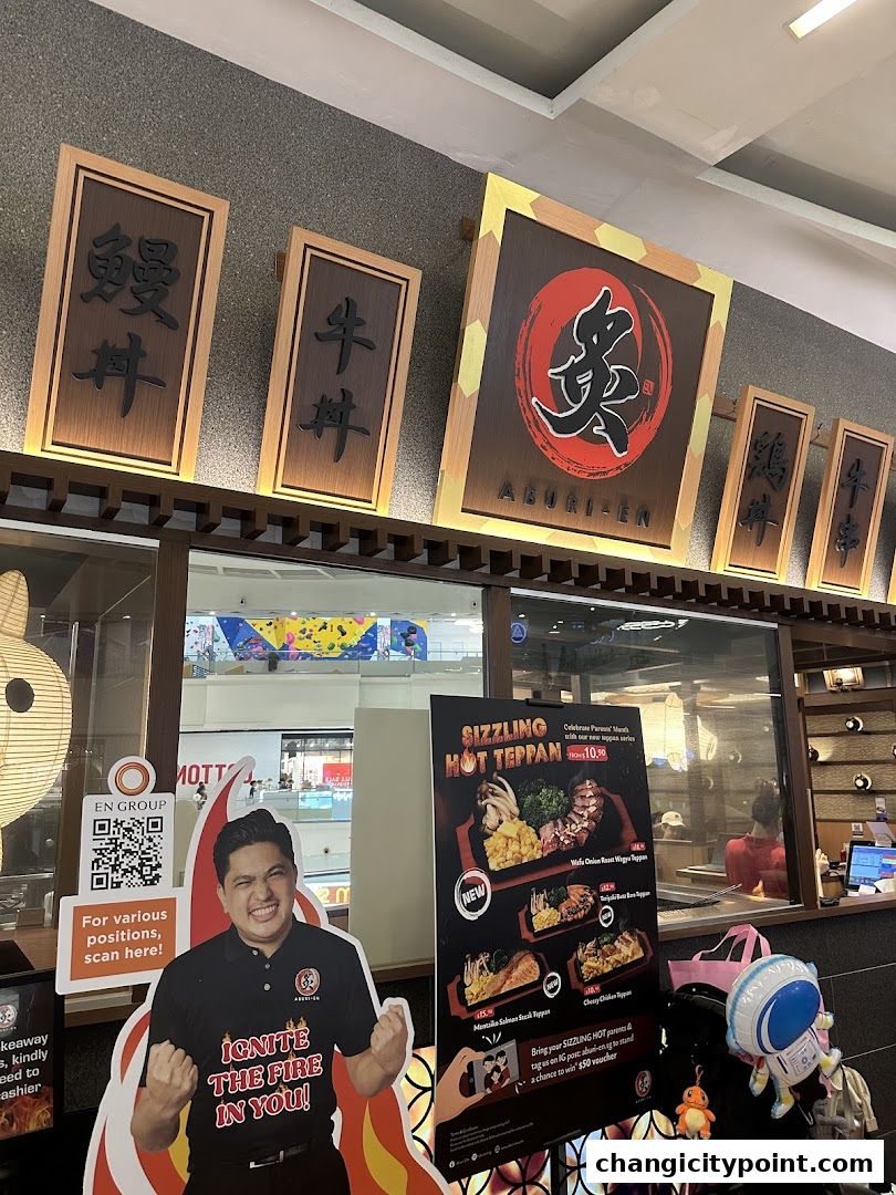 Aburi-EN restaurant entrance with signage, a promotional standee, and a menu display.