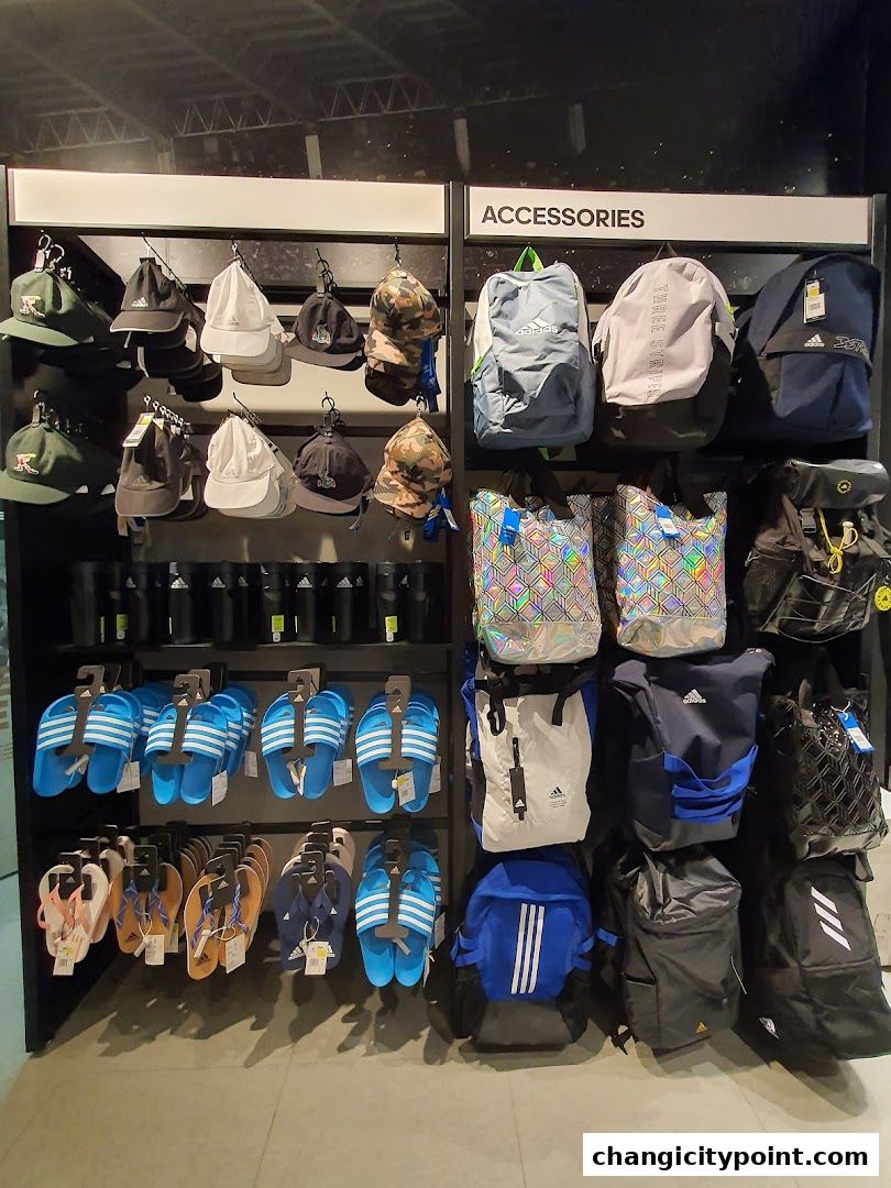 Adidas accessories including hats, backpacks, and flip-flops displayed on shelves.