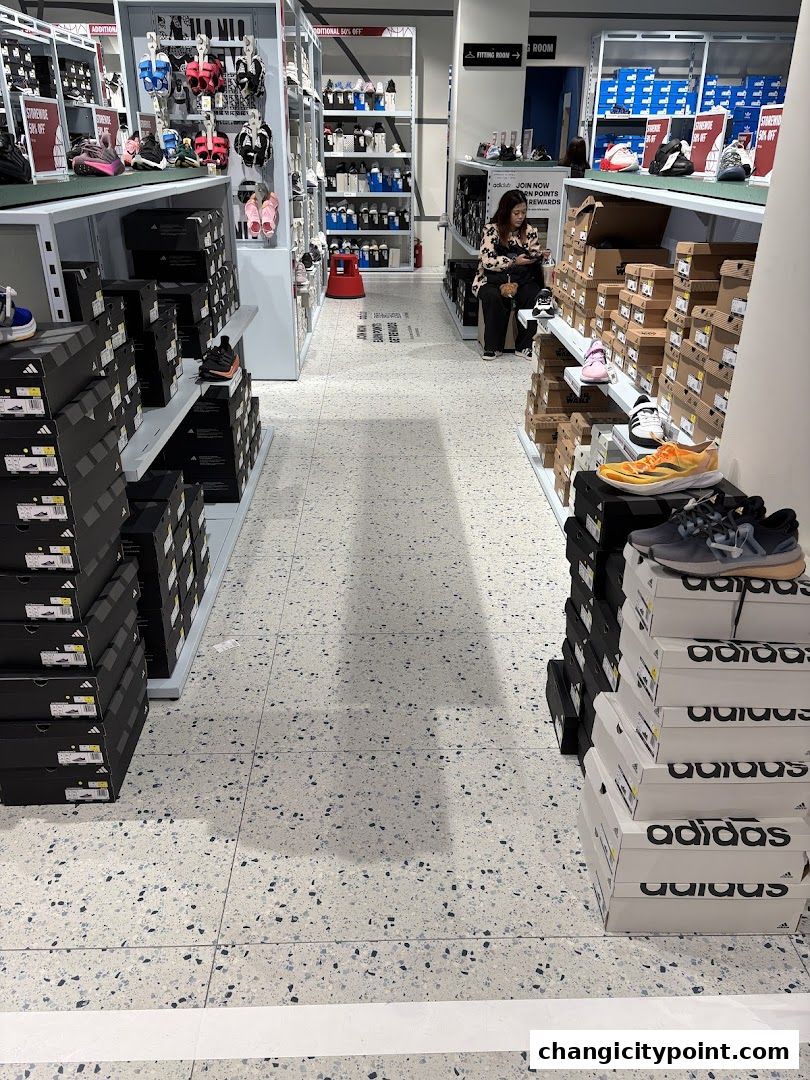 Interior view of an Adidas Factory Outlet store with shoes and boxes displayed.