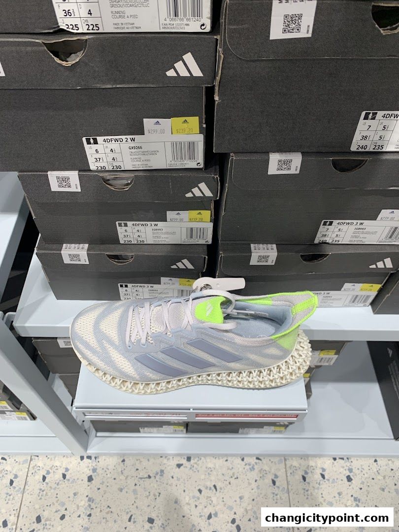 A display of Adidas shoes in boxes with a single shoe prominently featured.