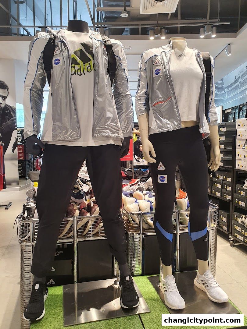 Mannequins display Adidas NASA-themed athletic wear and footwear.
