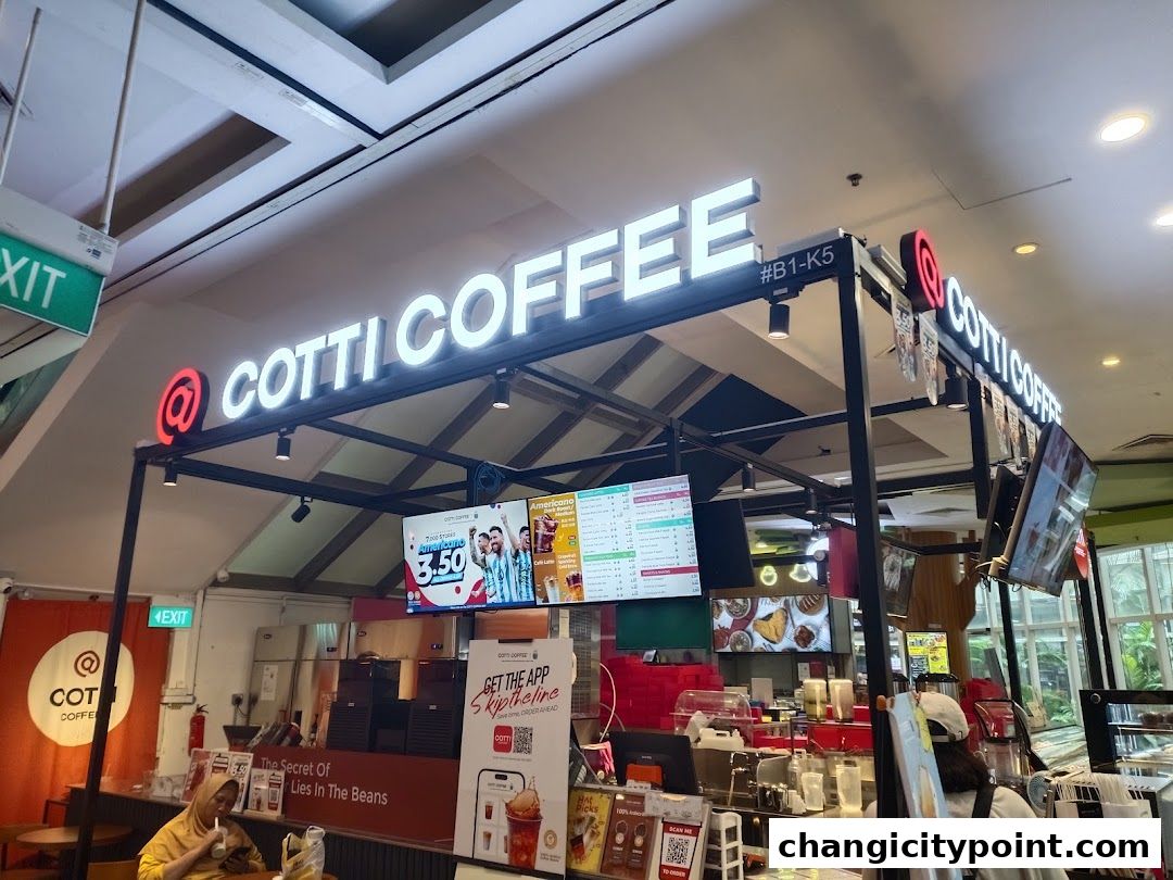 Exterior view of a Cotti Coffee shop with illuminated signage and digital menus.