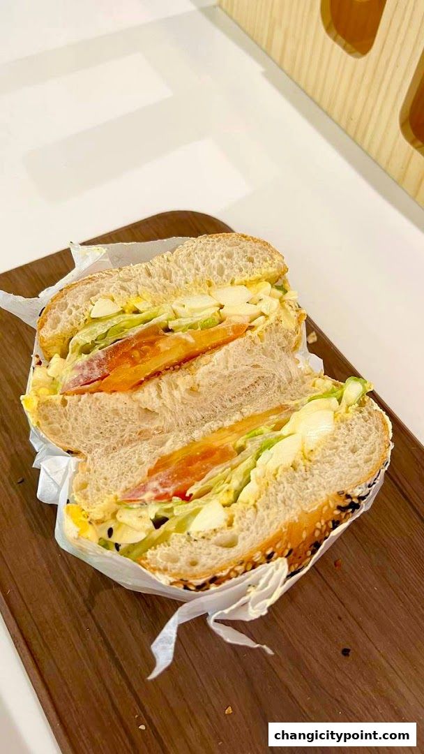 A delicious sandwich cut in half, showcasing fresh ingredients on a wooden board.