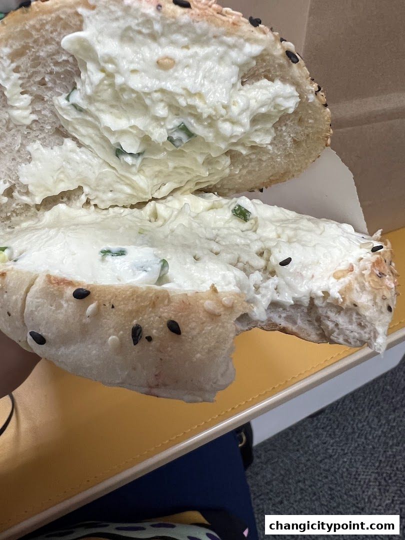 A close-up shot of a delicious bagel with cream cheese and chives.