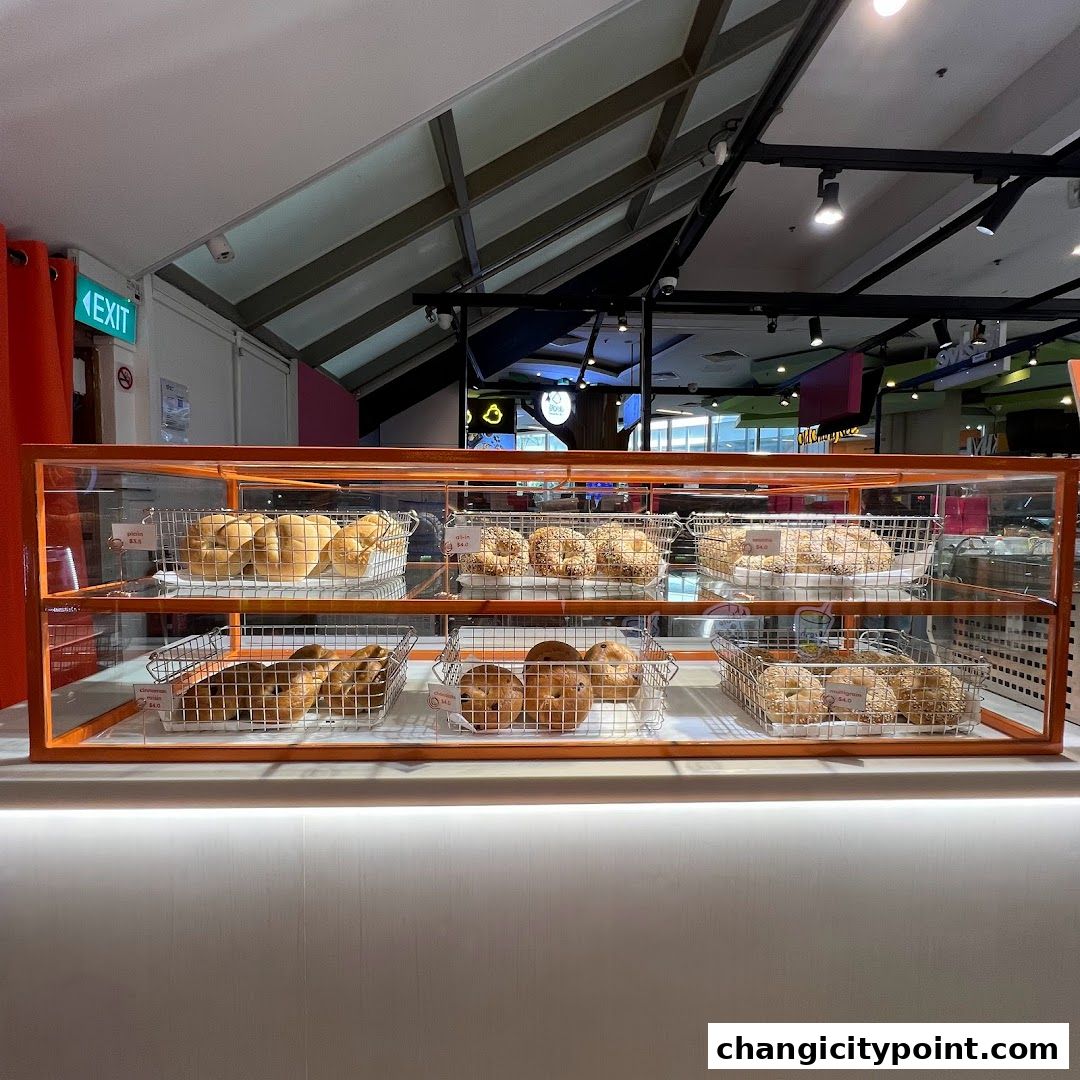 A display case filled with various types of bagels at the shop 'another bean'.
