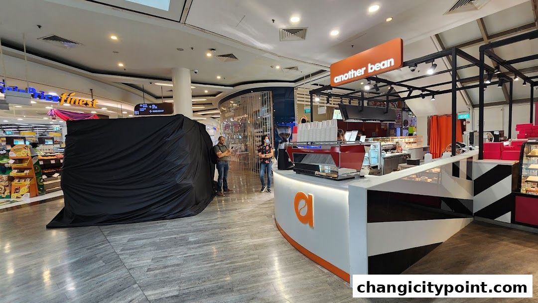 The 'another bean' coffee shop counter with espresso machine and pastries on display.