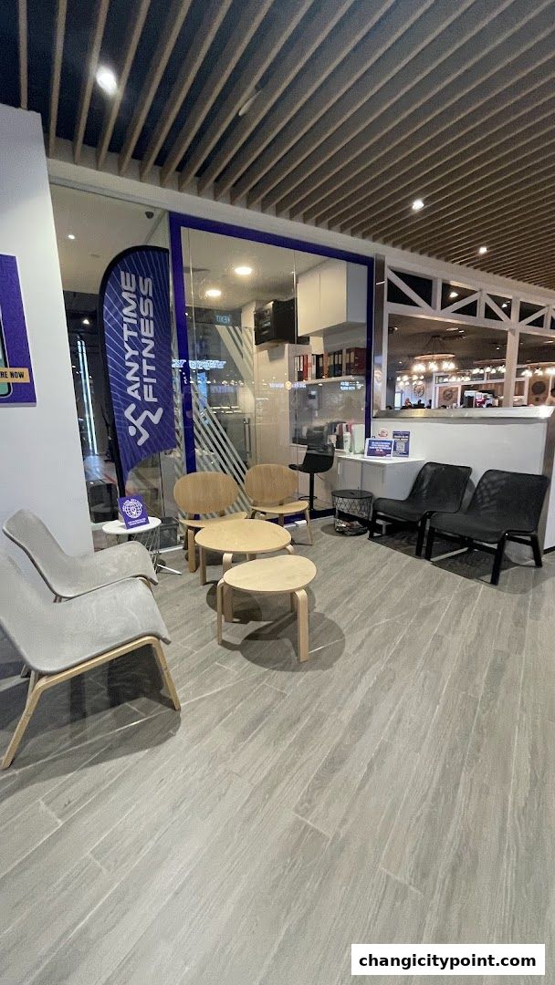 Waiting area with modern chairs and tables inside Anytime Fitness Changi.