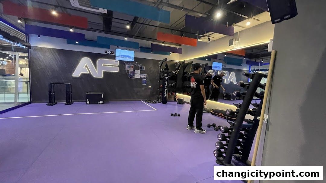 Interior of a modern gym with purple flooring, weights, and workout equipment.
