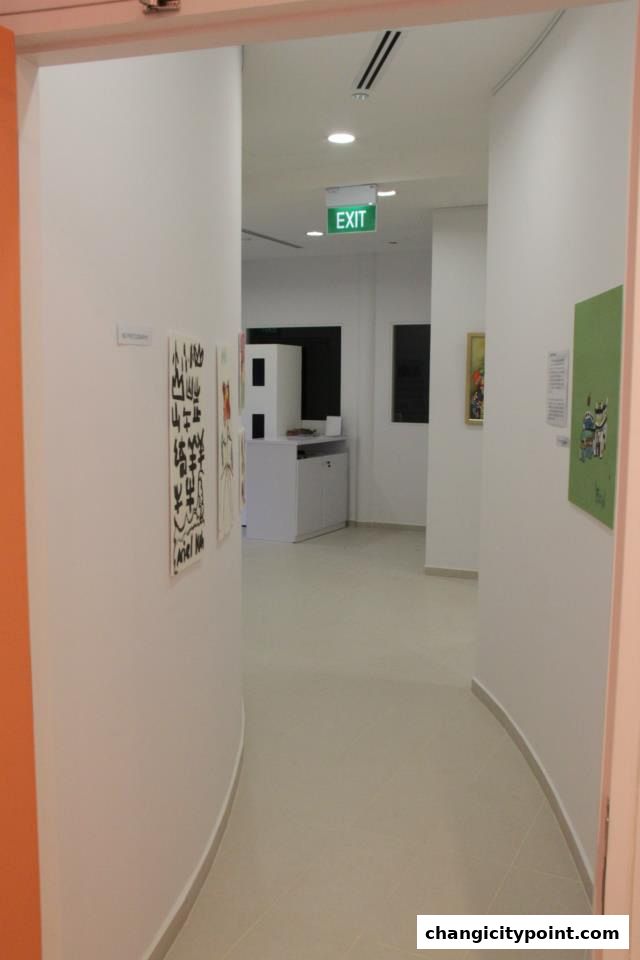 Interior view of an art gallery hallway with artwork displayed on the walls.