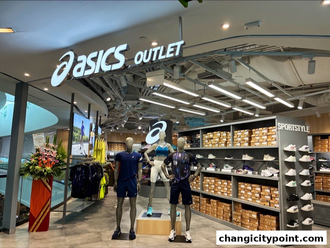 ASICS Outlet store entrance with mannequins displaying sportswear and shelves of shoes.