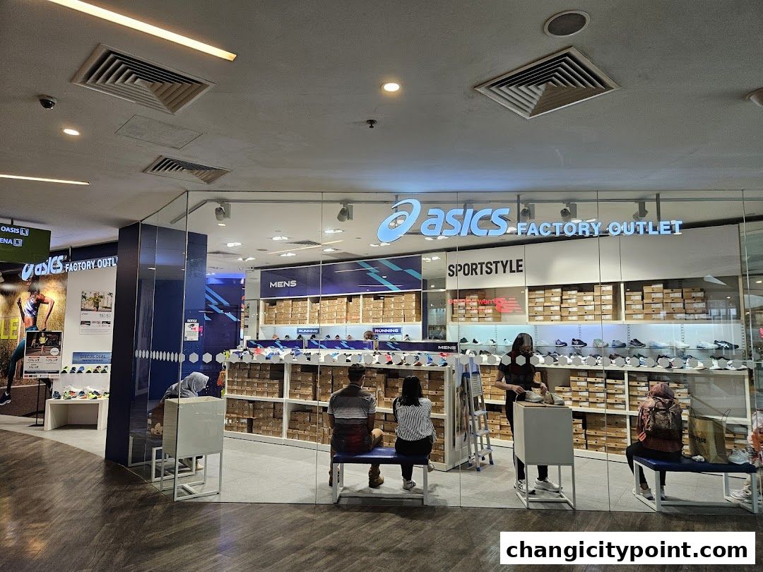 The ASICS Factory Outlet store entrance with shoes displayed and customers browsing.