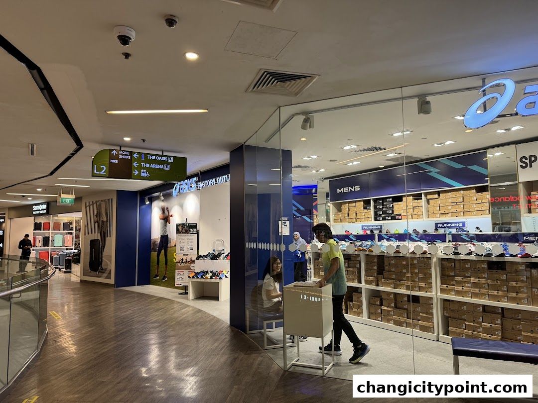 The entrance of an ASICS Factory Outlet store displaying shoes and boxes.