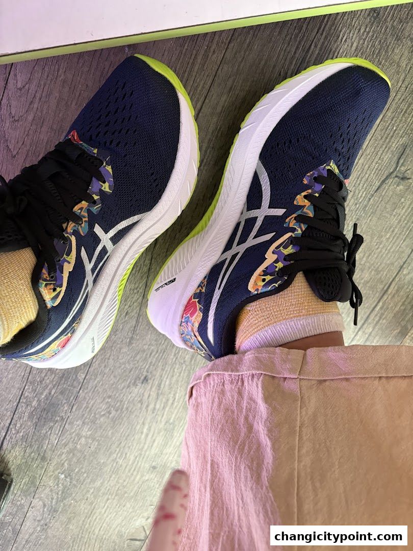 Close-up of navy blue ASICS running shoes with colorful accents and white soles.