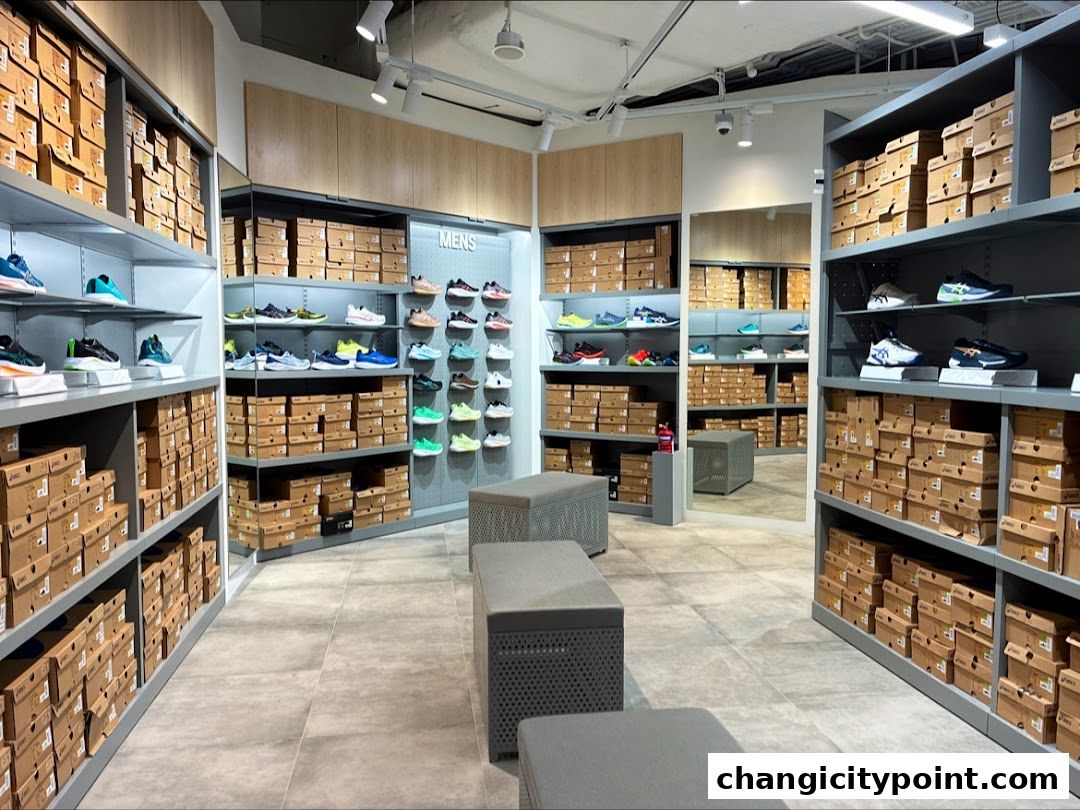 Interior view of an ASICS store showcasing shelves filled with shoe boxes and display shoes.