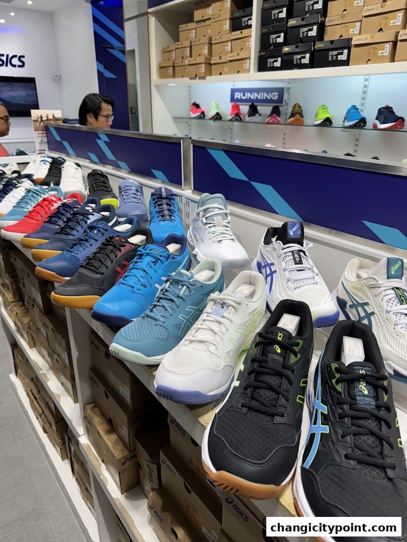 ASICS store interior showcasing a wide variety of athletic shoes displayed on shelves.