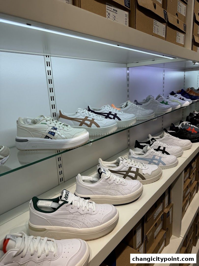 Rows of ASICS sneakers displayed on shelves in a retail store.