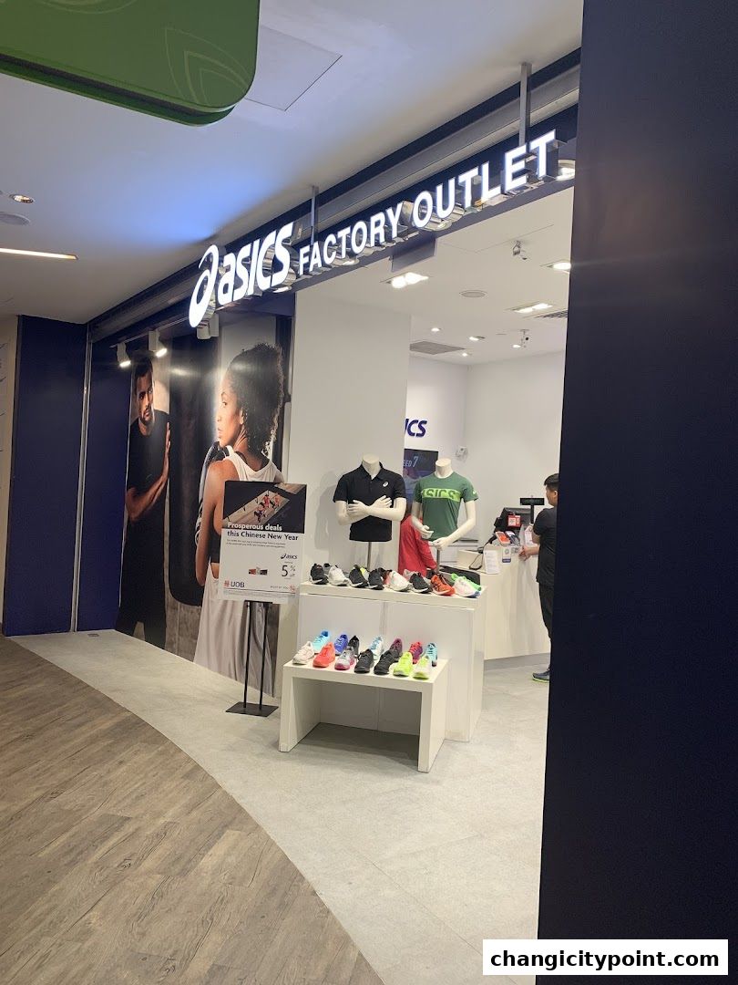 The ASICS Factory Outlet store entrance displays shoes and apparel, with a promotional sign.
