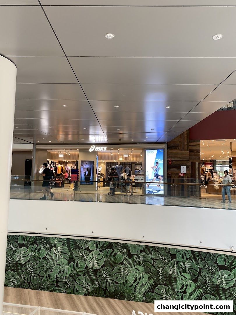 The ASICS store entrance with displays of athletic wear and people browsing inside.