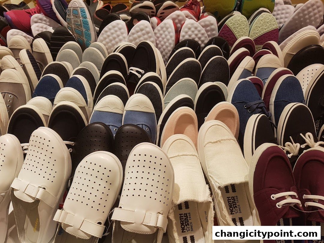 A large collection of various shoes, including sneakers and casual footwear, neatly arranged.