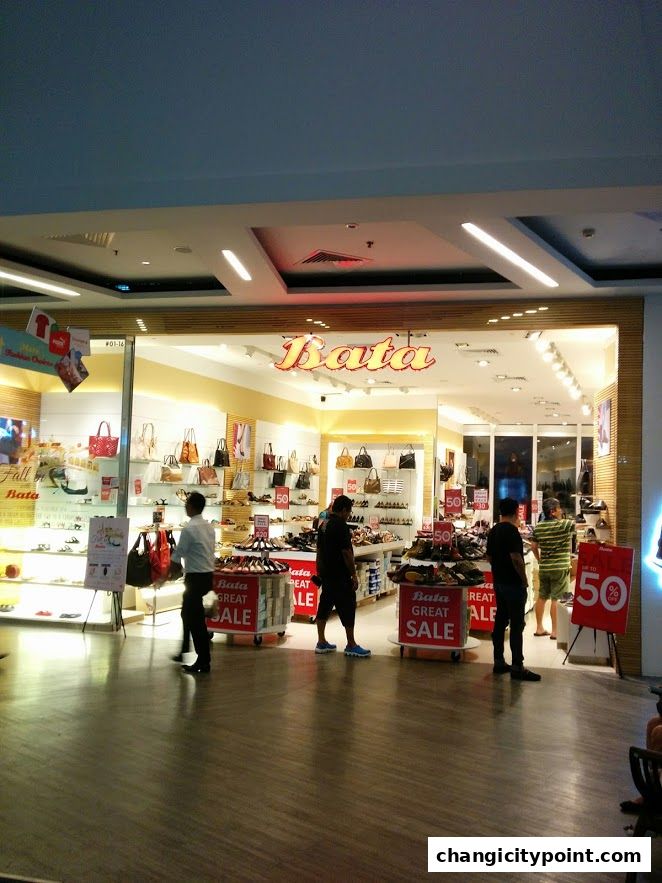 The exterior of a Bata shoe store with bags and shoes on display, featuring a sale.