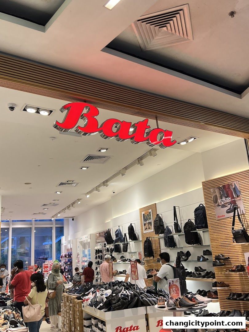 Interior view of a Bata shoe store with displays of shoes and bags, and customers browsing.