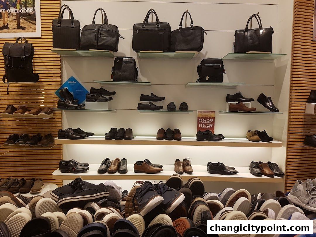 A display of various shoes and handbags on shelves in a Bata store.