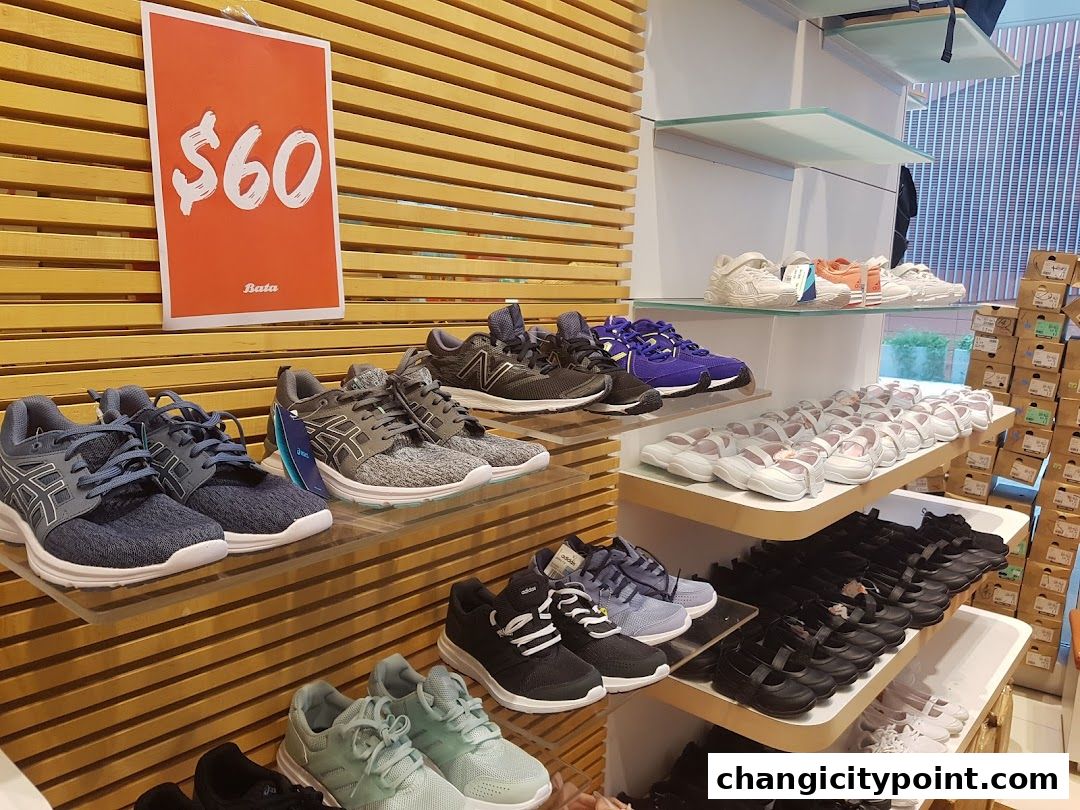 A display of various athletic and casual shoes on shelves in a Bata store.