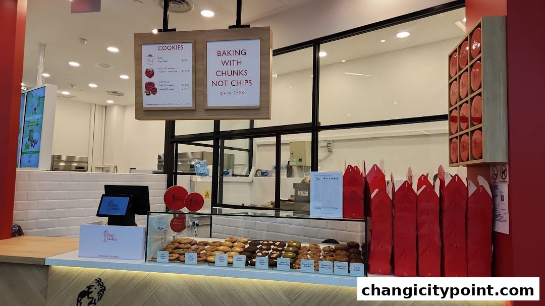 A display of freshly baked cookies at Ben's Cookies, with a menu and branded packaging.
