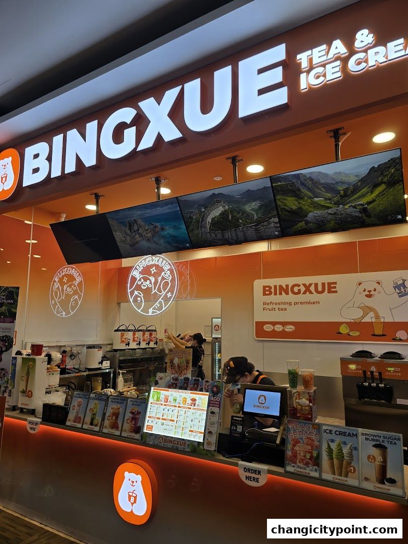 BingXue Tea & Ice Cream shop counter with staff serving customers and displaying menu items.