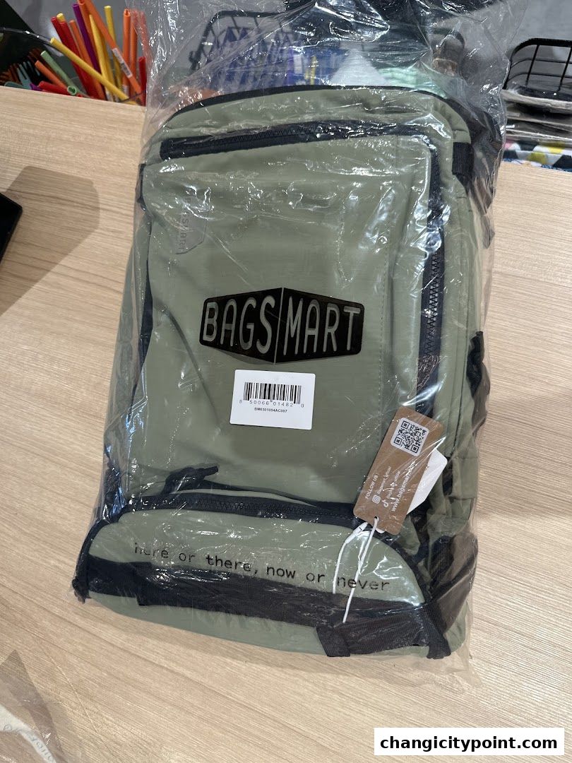 A green backpack from Bagsmart is shown, packaged in plastic, with a motivational quote.