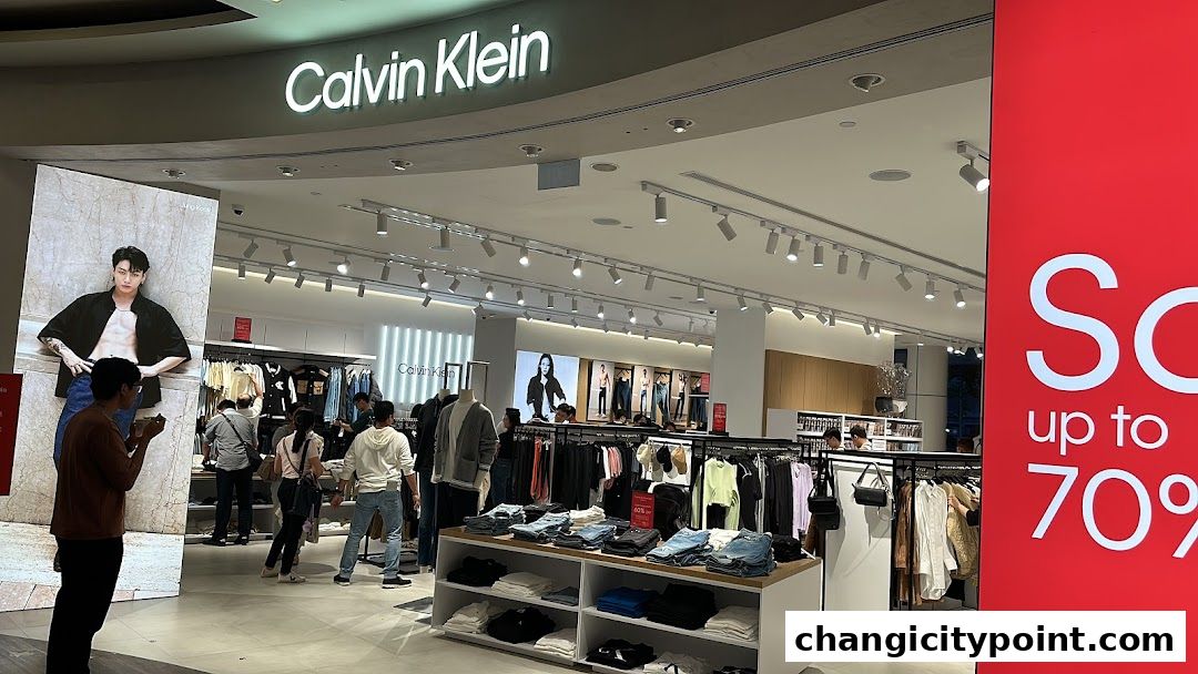 Calvin Klein store interior with clothing displays and a large sale banner.