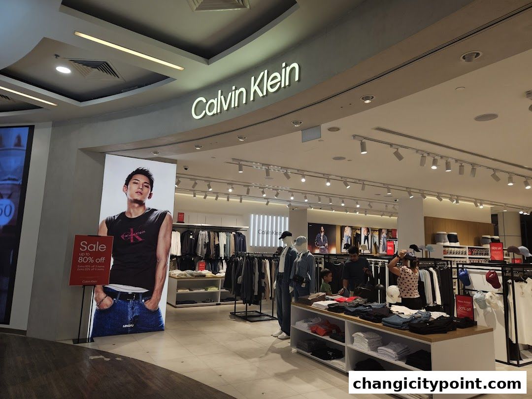 Interior view of a Calvin Klein store with clothing displays and a large promotional poster.