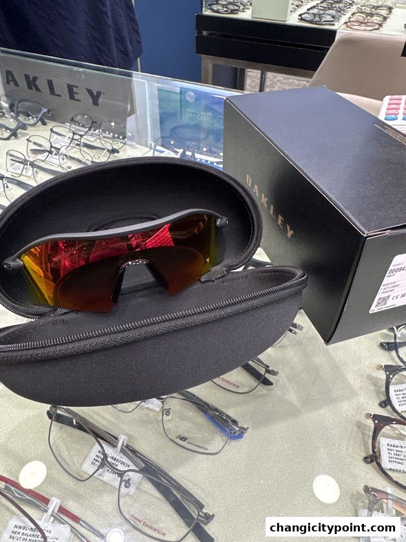 Oakley sunglasses in a case with a box and various eyeglasses on display.