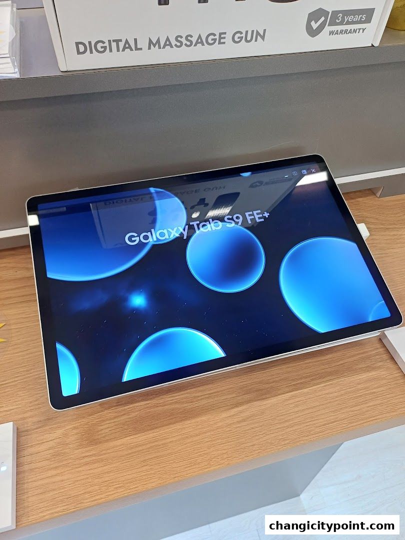 A Samsung Galaxy Tab S9 FE+ tablet is displayed on a wooden counter.