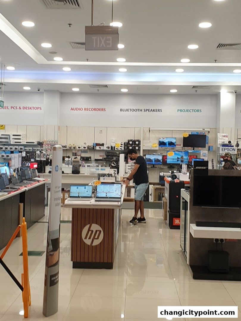 Interior of an electronics store with various gadgets and displays, including laptops and audio equipment.
