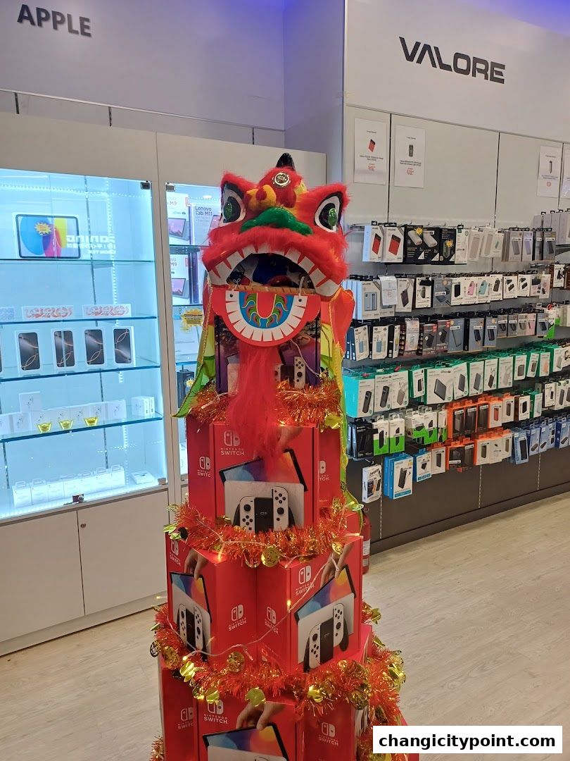 A festive display of Nintendo Switch boxes and a lion dance head in a tech store.