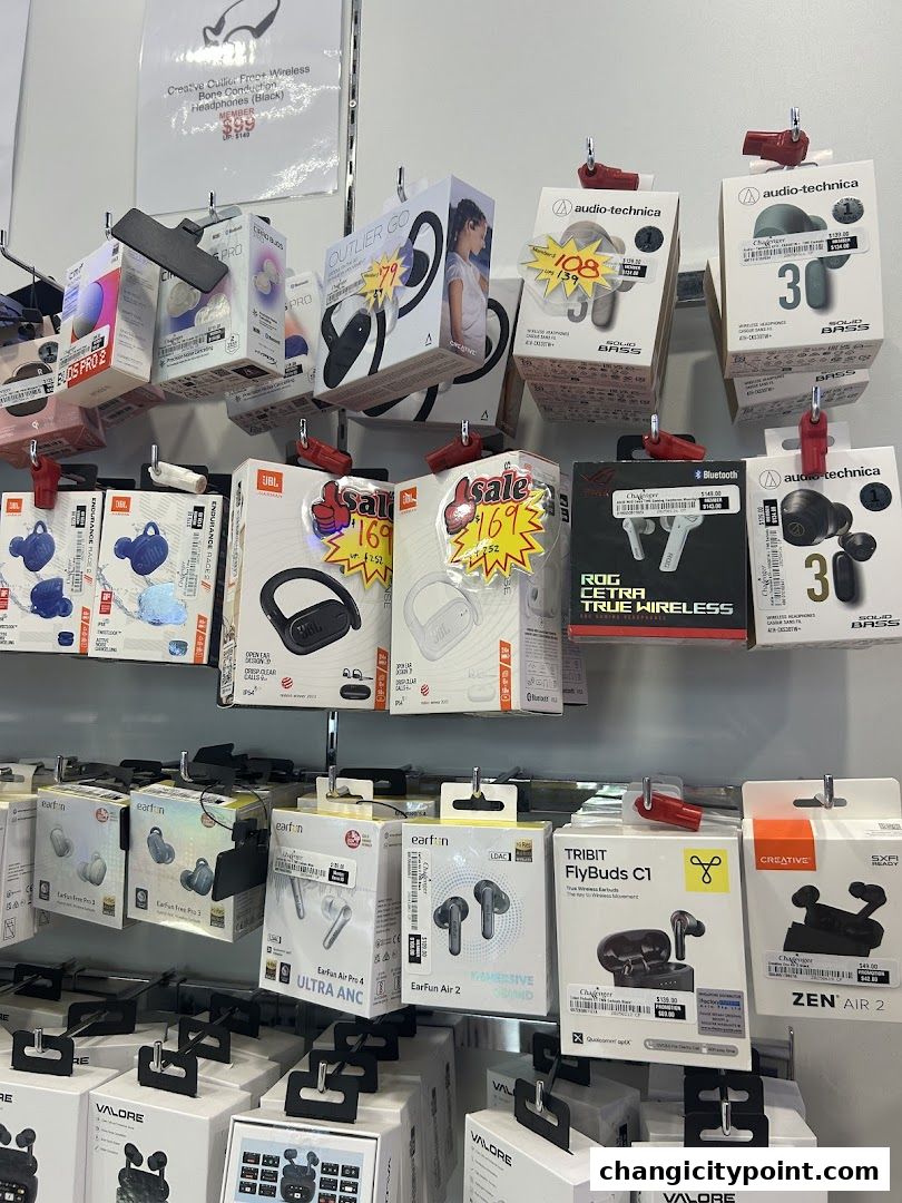 A wall display of various wireless earbuds and headphones from different brands.
