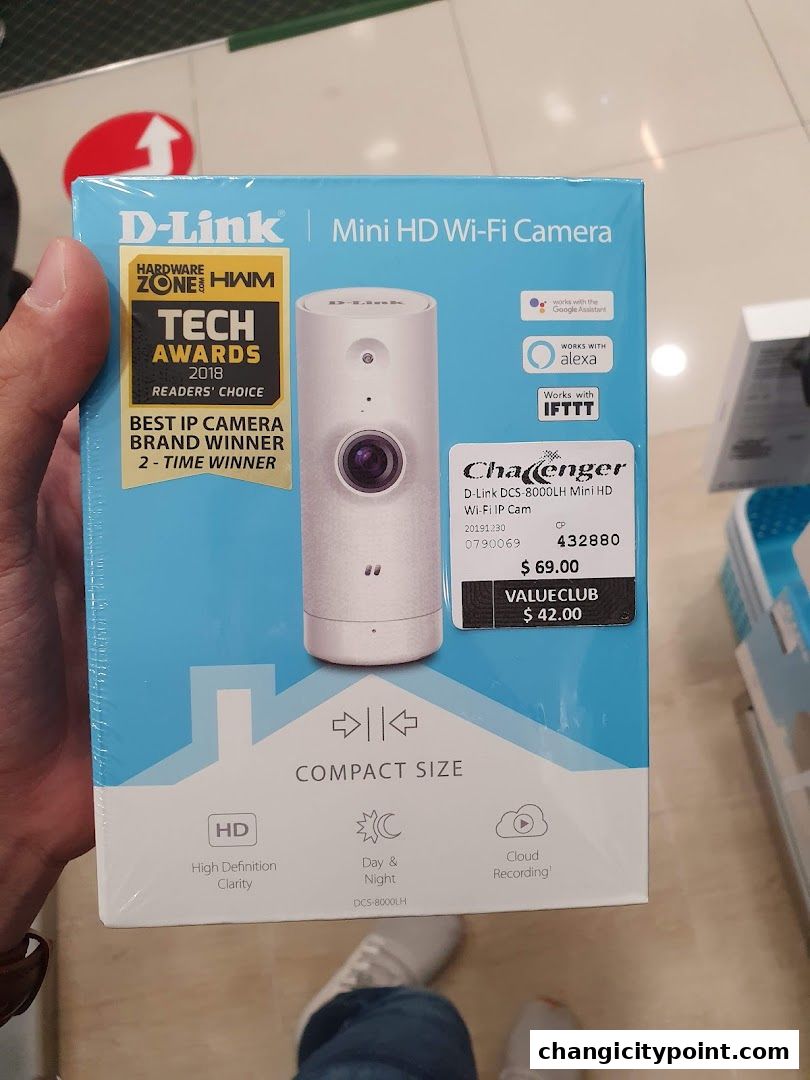 A hand holds a box for a D-Link Mini HD Wi-Fi Camera, highlighting awards and features.