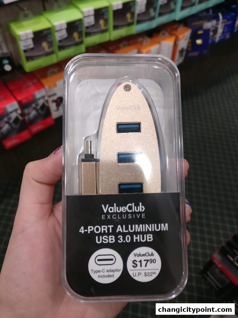 A hand holds a ValueClub exclusive 4-port aluminum USB 3.0 hub.