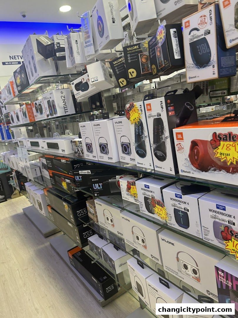 A retail store display showcasing various portable speakers and audio devices on shelves.
