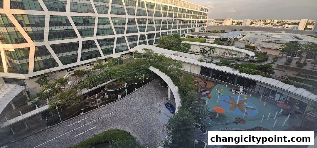 An aerial view of Changi City Point Carpark with a modern building and a children's play area.