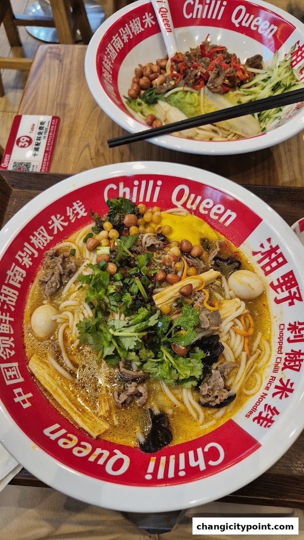 Two bowls of delicious rice noodles with various toppings, served at Chilli Queen.
