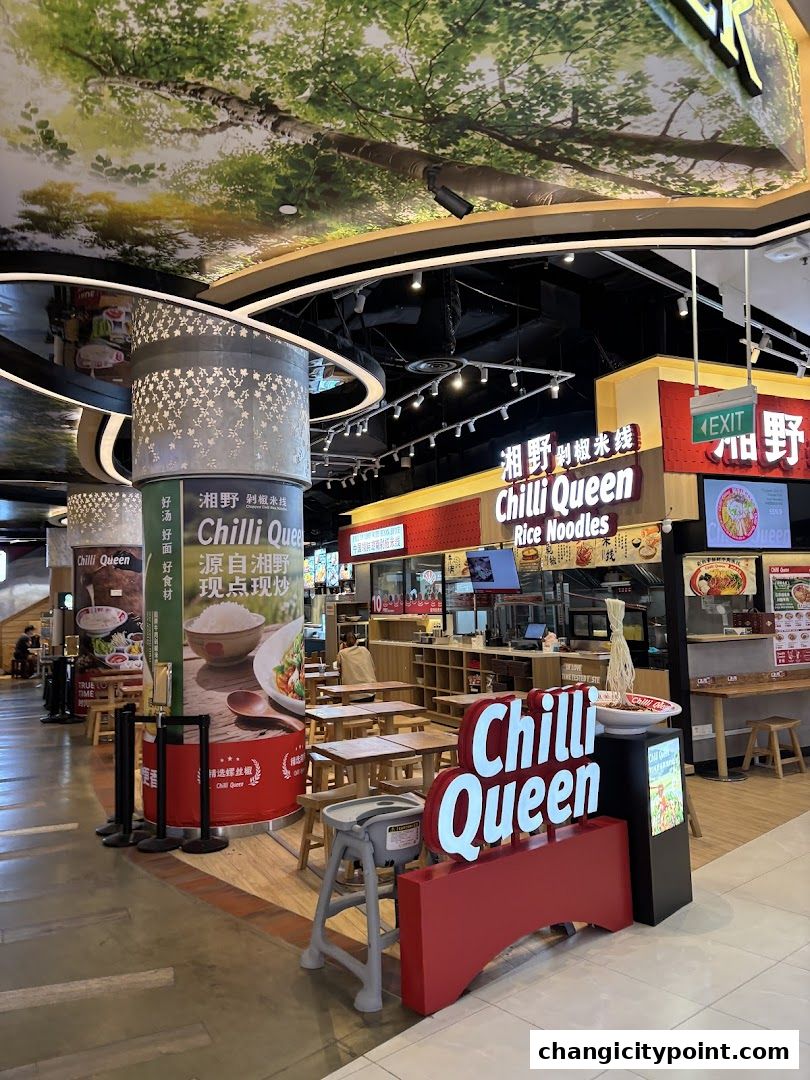 The exterior of Chilli Queen Rice Noodles shop with seating and signage.