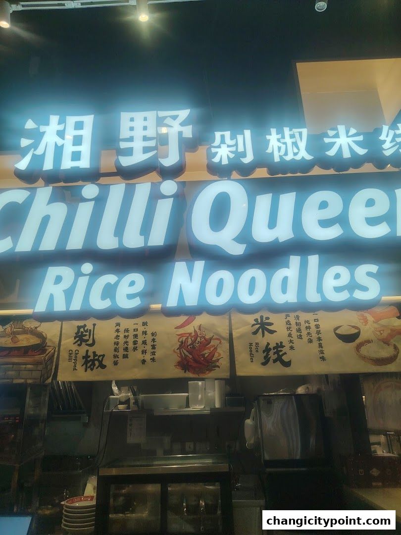 The illuminated sign for Chilli Queen Rice Noodles with Chinese characters above.