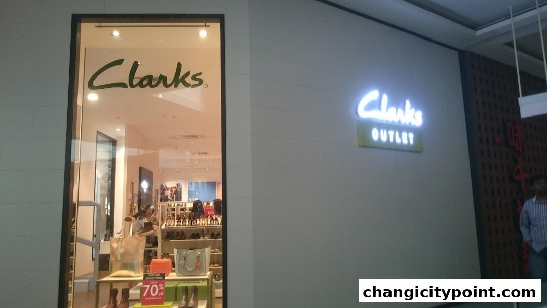 The exterior of a Clarks Outlet store with shoes and bags displayed in the window.