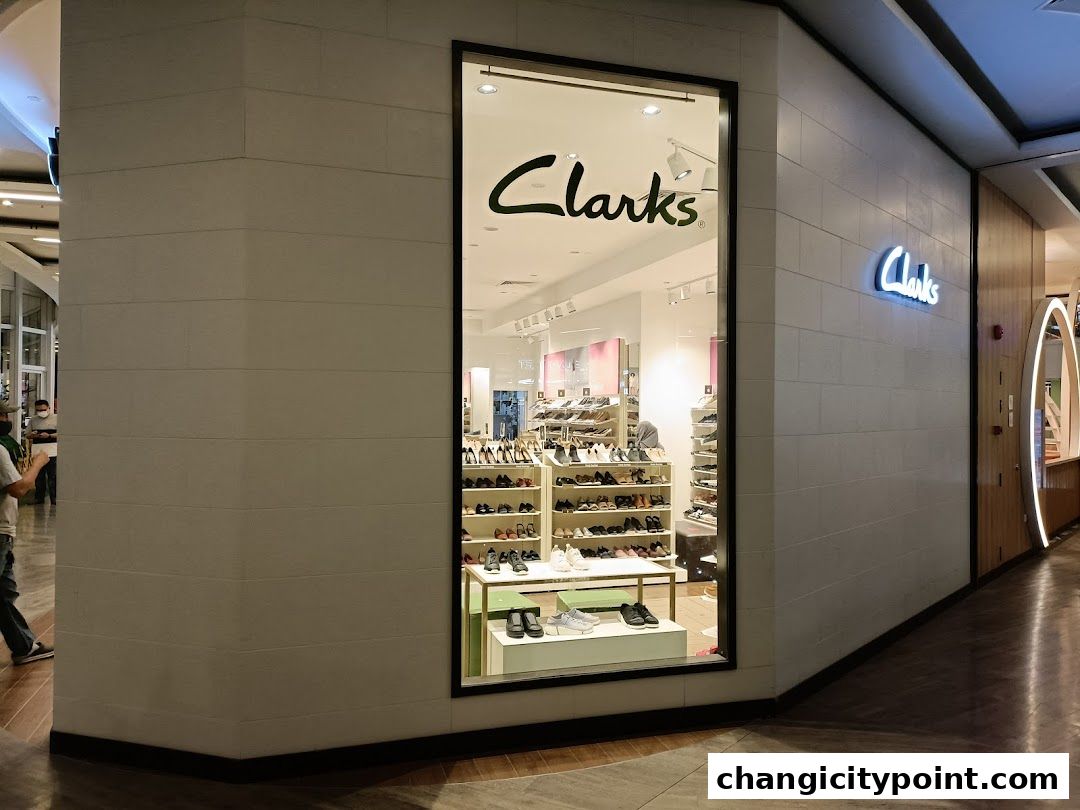 The exterior of a Clarks Outlet shoe store with a large display window showcasing shoes.