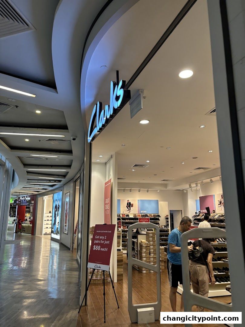 The entrance of a Clarks Outlet store with a promotional sign and shoe displays visible.