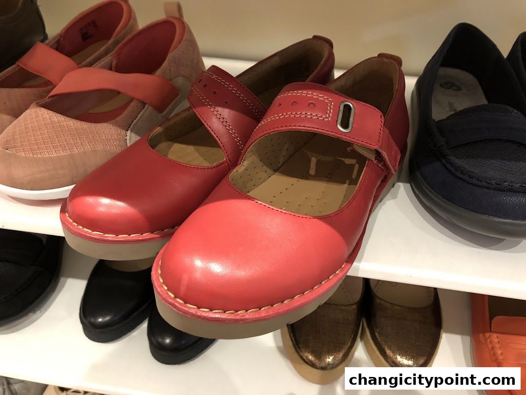 A close-up view of various women's shoes displayed on white shelves.